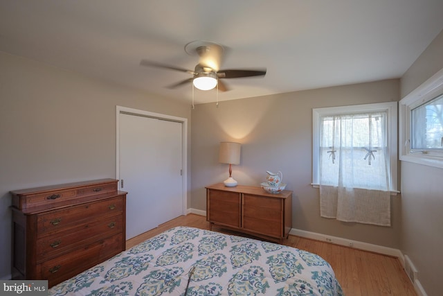 bedroom featuring a ceiling fan, visible vents, baseboards, and light wood finished floors