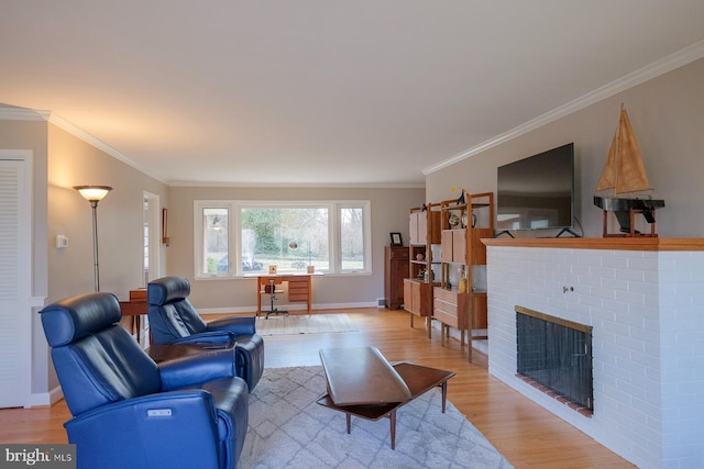 living area with light wood-style flooring, a brick fireplace, baseboards, and ornamental molding