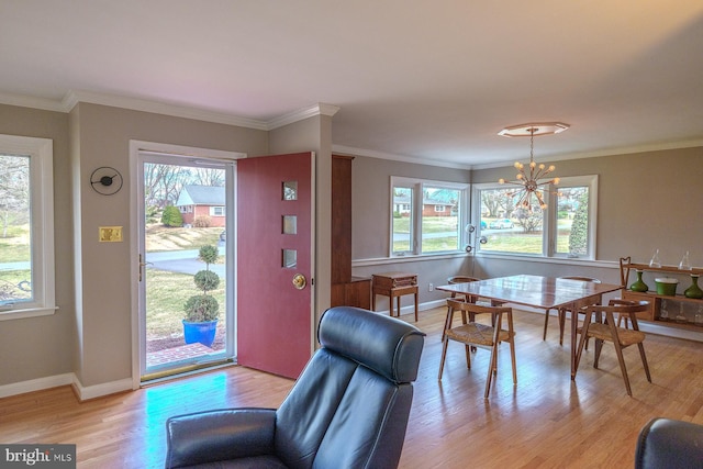 foyer with an inviting chandelier, baseboards, light wood-type flooring, and ornamental molding