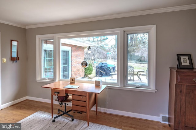 office space with visible vents, crown molding, baseboards, and wood finished floors