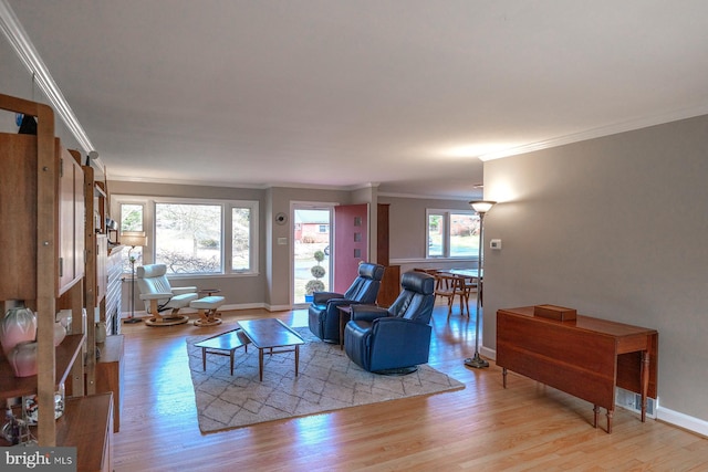 living room with light wood-style flooring, baseboards, and ornamental molding