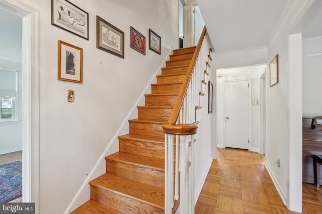 staircase featuring baseboards and ornamental molding