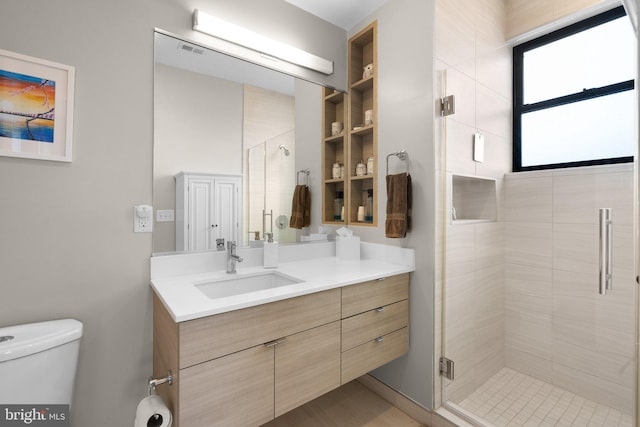 full bath with vanity, a shower stall, toilet, and visible vents