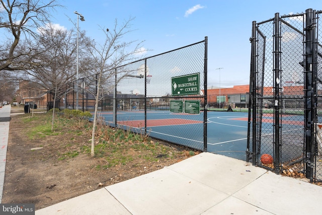 view of basketball court featuring a gate, community basketball court, and fence