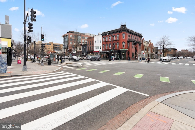 view of road featuring street lights, curbs, sidewalks, and traffic lights