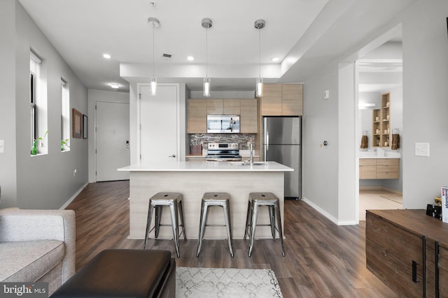 kitchen with decorative backsplash, light countertops, dark wood-type flooring, appliances with stainless steel finishes, and modern cabinets