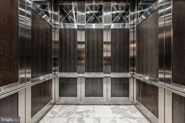 spacious closet with marble finish floor and elevator