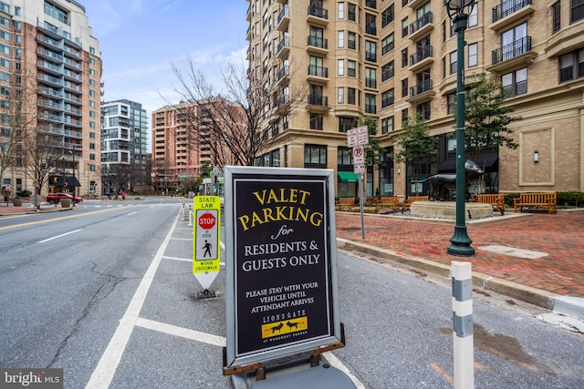 exterior space with sidewalks, traffic signs, street lights, and curbs