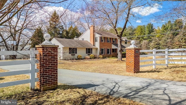 view of front of home featuring a fenced front yard and a chimney