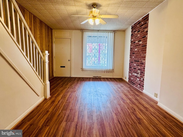 interior space with ceiling fan, stairway, visible vents, and wood finished floors