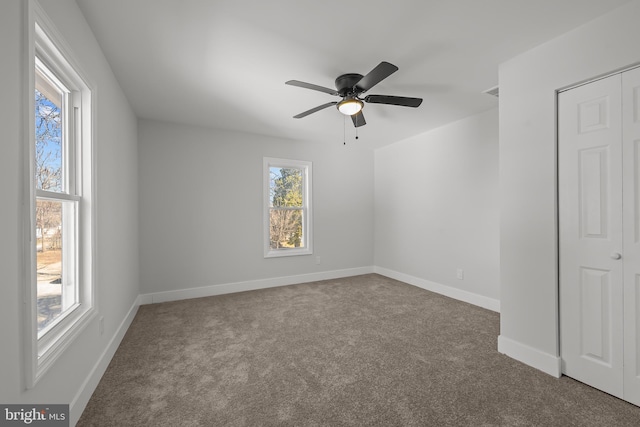 unfurnished room with carpet floors, baseboards, and a ceiling fan