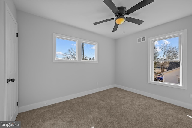 unfurnished bedroom featuring baseboards, multiple windows, visible vents, and carpet flooring