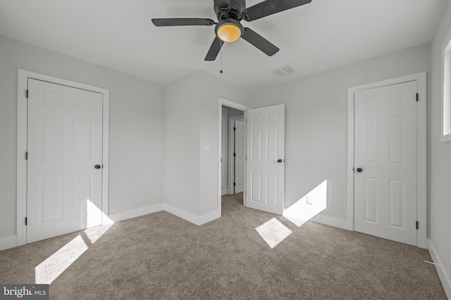 unfurnished bedroom featuring a ceiling fan, carpet flooring, visible vents, and baseboards