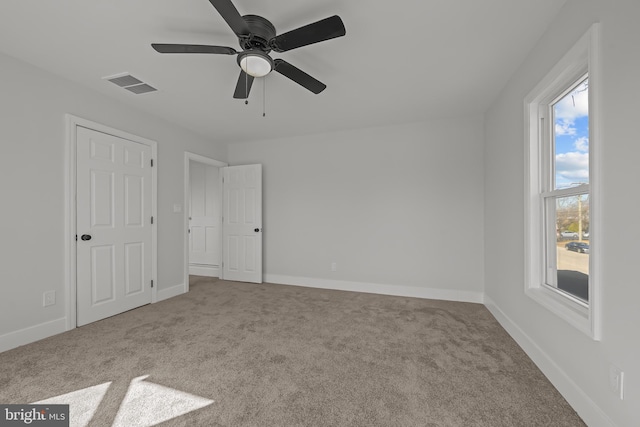 unfurnished bedroom with carpet floors, baseboards, and visible vents