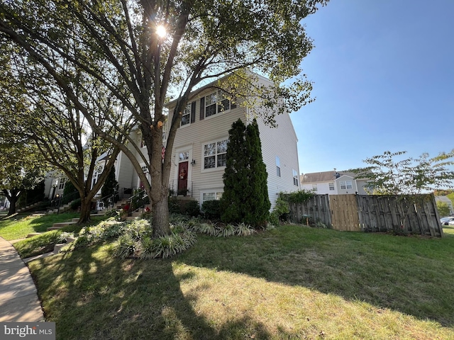 view of side of home with a yard and fence