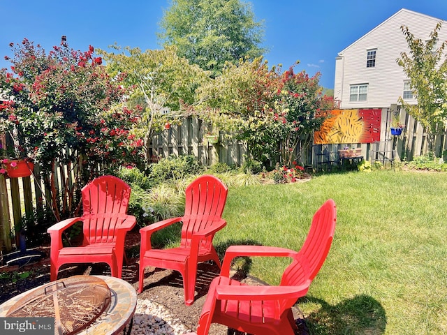 view of yard with fence and an outdoor fire pit