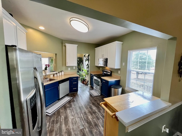 kitchen featuring light countertops, appliances with stainless steel finishes, white cabinetry, blue cabinets, and a sink