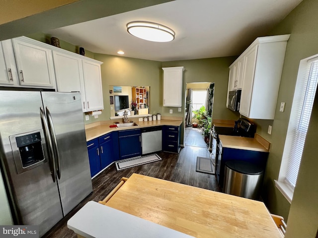 kitchen featuring dark wood finished floors, stainless steel appliances, blue cabinets, and light countertops