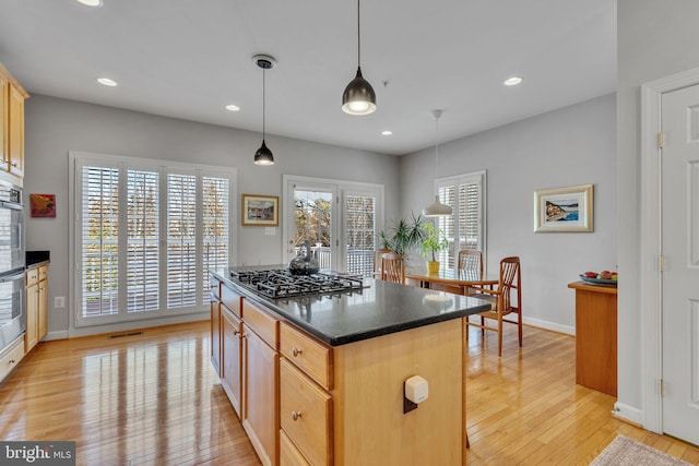 kitchen with a center island, decorative light fixtures, recessed lighting, light wood-style floors, and gas stovetop