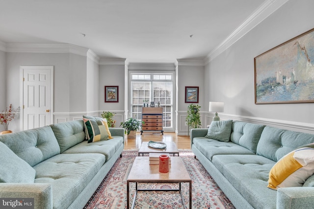 living area featuring a decorative wall, wood finished floors, a wainscoted wall, and ornamental molding