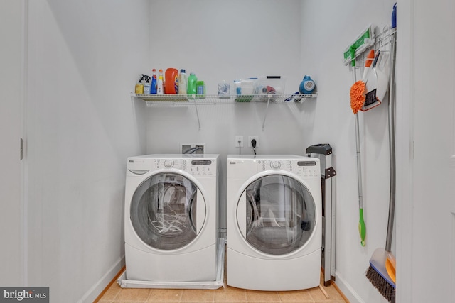 laundry room with baseboards, laundry area, and washing machine and clothes dryer