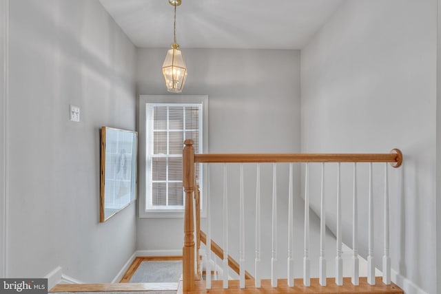 stairs with a chandelier and baseboards