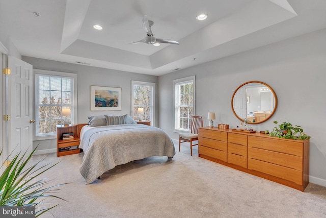 bedroom with light carpet, recessed lighting, baseboards, and a tray ceiling