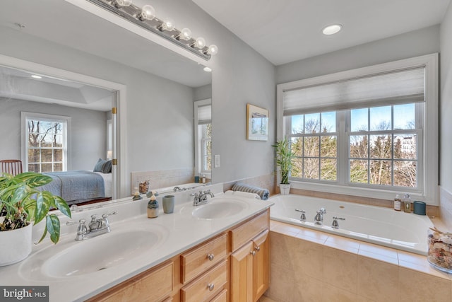 full bathroom featuring double vanity, connected bathroom, a garden tub, and a sink