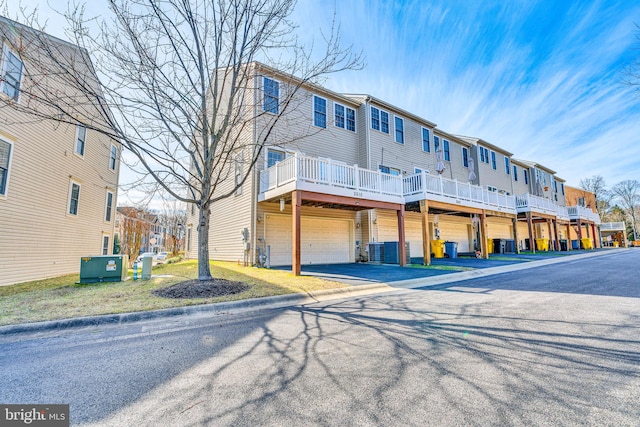 exterior space featuring central air condition unit, an attached garage, and driveway