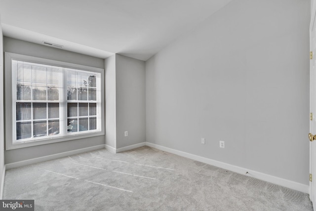 carpeted spare room with visible vents and baseboards