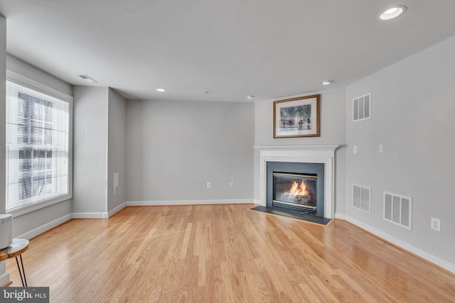 unfurnished living room with light wood-type flooring, visible vents, and recessed lighting