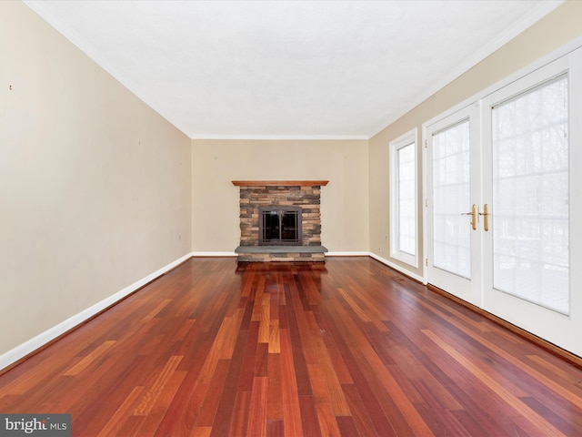 unfurnished living room featuring a fireplace, crown molding, baseboards, and wood finished floors