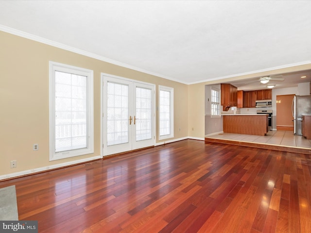 unfurnished living room featuring crown molding, light wood-style floors, and french doors