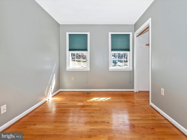 spare room with visible vents, baseboards, and light wood finished floors