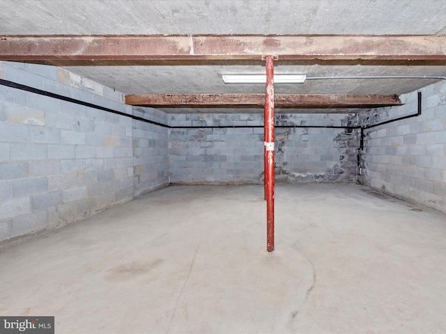 unfinished basement featuring concrete block wall