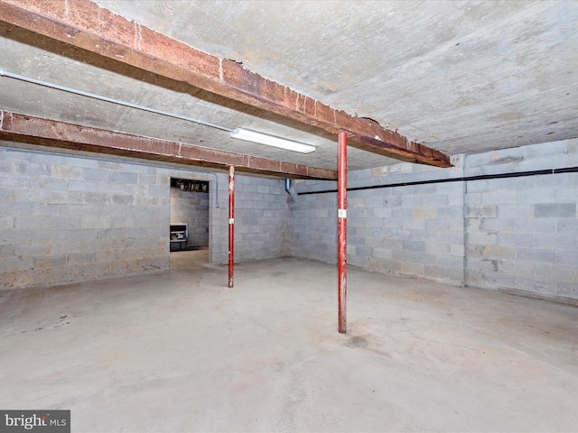 unfinished basement featuring concrete block wall