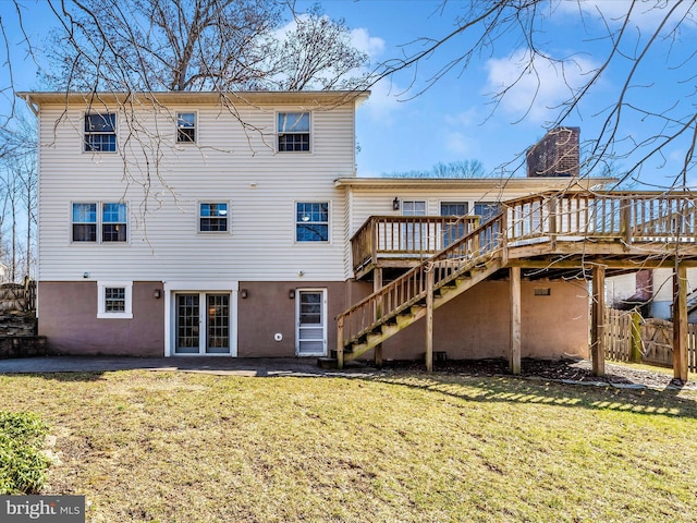 rear view of house featuring a deck, fence, stairway, a yard, and a chimney