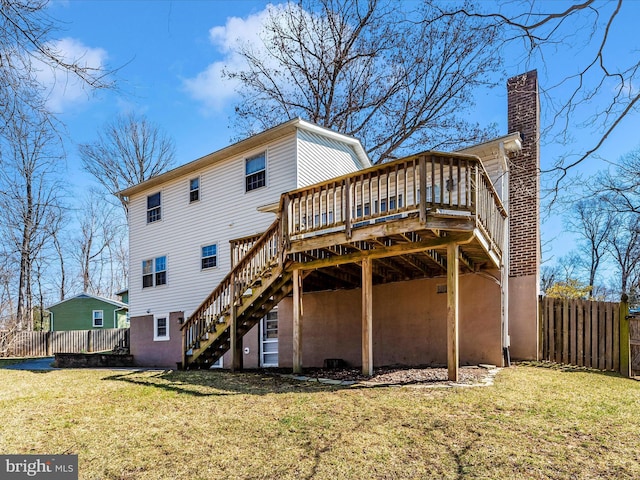 back of property with stairway, a lawn, a wooden deck, and fence