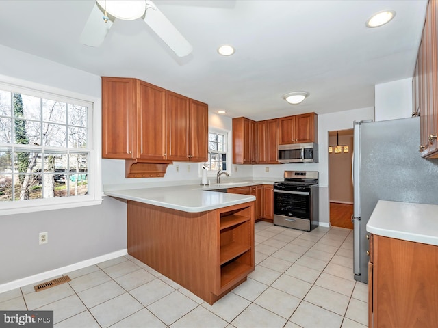 kitchen featuring light tile patterned floors, visible vents, appliances with stainless steel finishes, and a peninsula