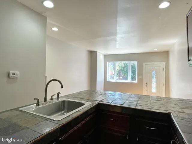 kitchen featuring recessed lighting, a sink, and tile countertops