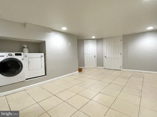 laundry area with washer and dryer, laundry area, light tile patterned flooring, and baseboards