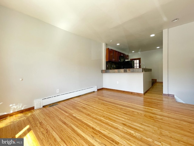 unfurnished living room featuring baseboards, a baseboard radiator, light wood-style flooring, and recessed lighting