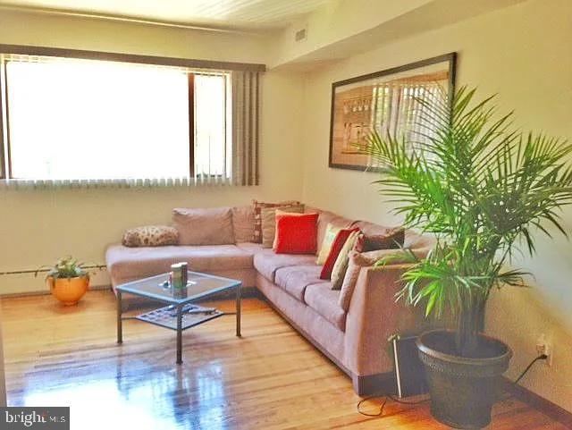 living area with a baseboard radiator and wood finished floors