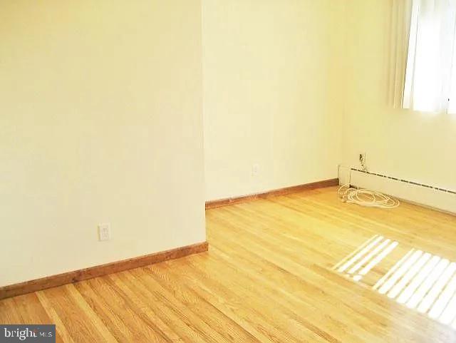 empty room with baseboards and wood finished floors