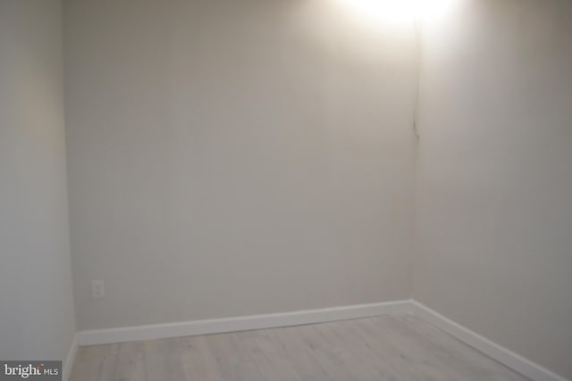 spare room featuring light wood finished floors and baseboards