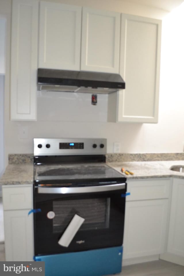 kitchen featuring stainless steel range with electric cooktop, white cabinets, and under cabinet range hood