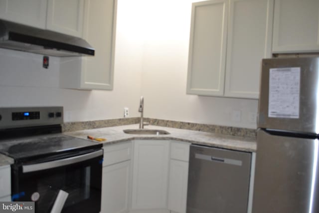 kitchen with stainless steel appliances, a sink, white cabinetry, and under cabinet range hood