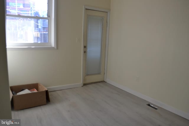 spare room featuring baseboards and wood finished floors