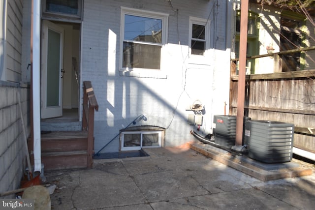 property entrance with cooling unit and brick siding