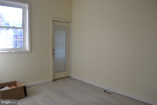 spare room with light wood-type flooring and baseboards